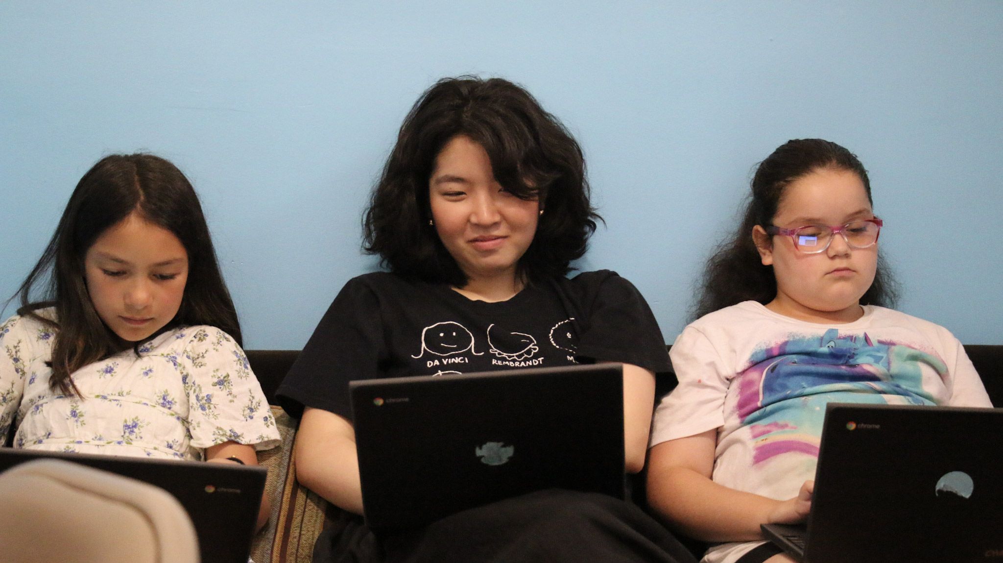 Teen Volunteer and young writers on their laptops