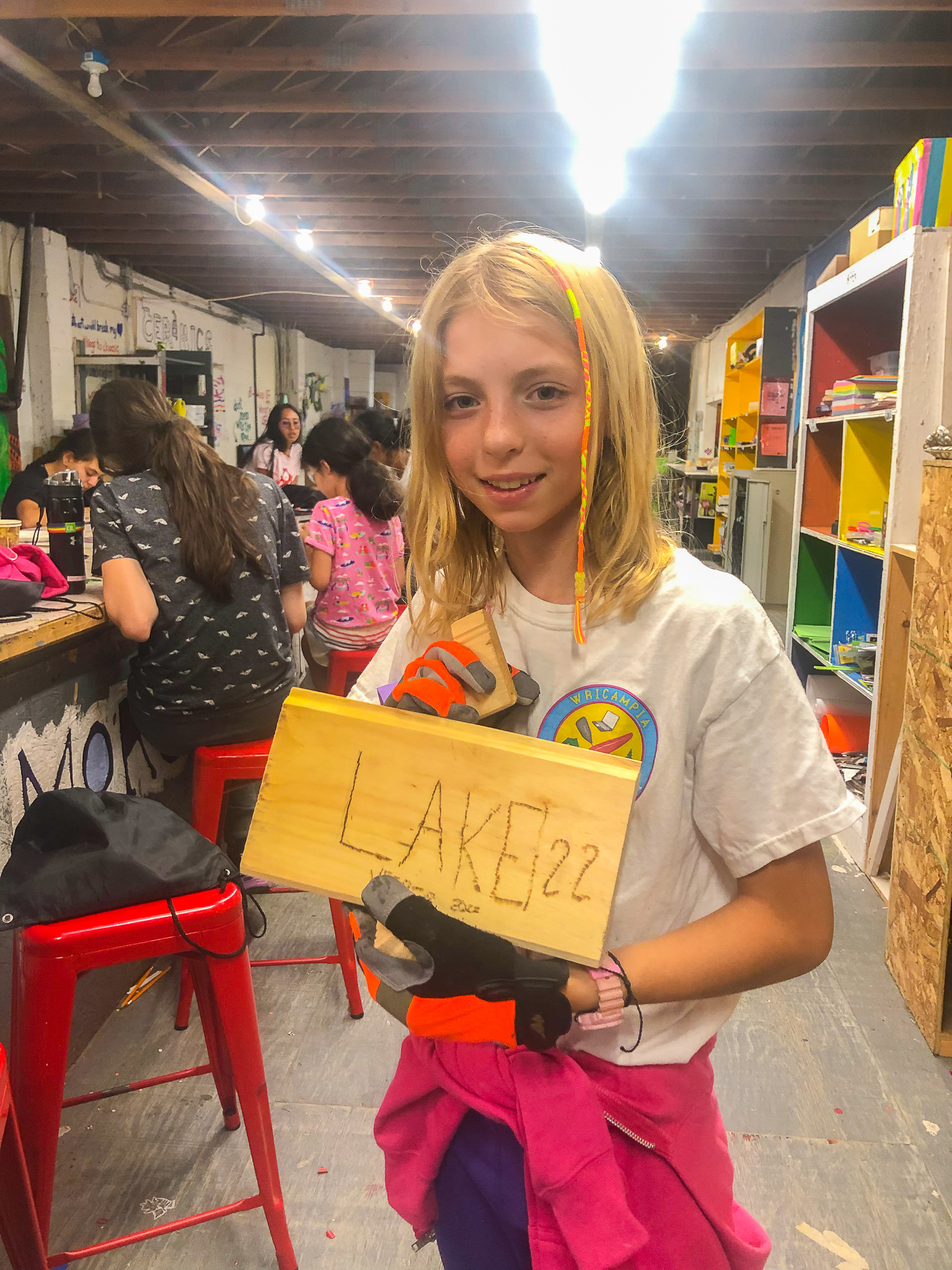 Camper holding a woodburning piece